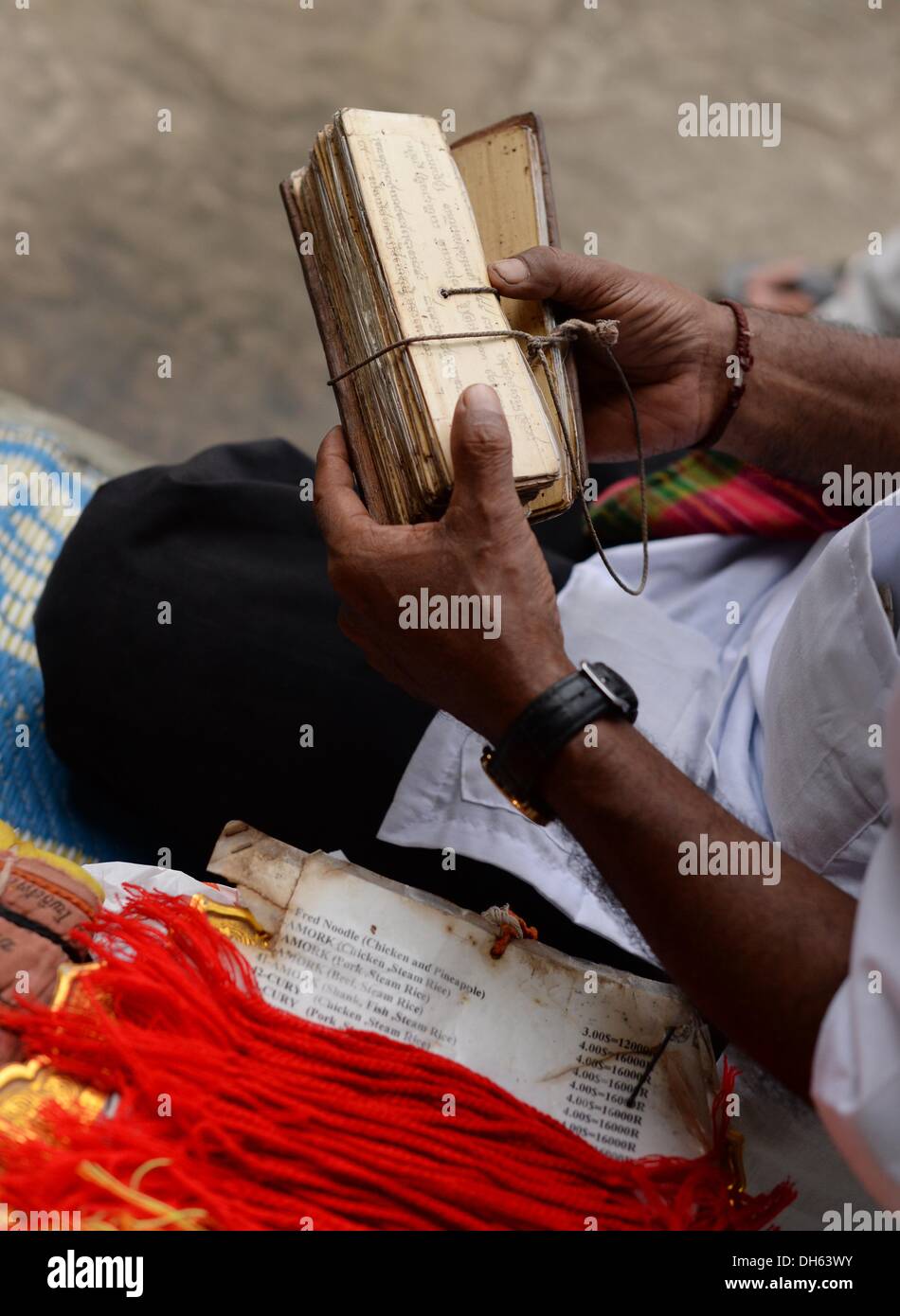 Siem Reap, Cambogia. Xiii oct, 2013. Un Buddista detiene scritto pagine di bambù per una cerimonia nel tempio buddista complesso Angkor Wat vicino a Siem Reap, Cambogia, 13 ottobre 2013. Il tempio è il più grande monumento religioso al mondo ed è stato costruito dal re Khmer Suryavarman II nei primi anni del XII secolo. Nel 1860, le rovine del tempio sono state ritrovate dal ricercatore Francese Henri Mouhot. Foto: Jens Kalaene/dpa/Alamy Live News Foto Stock