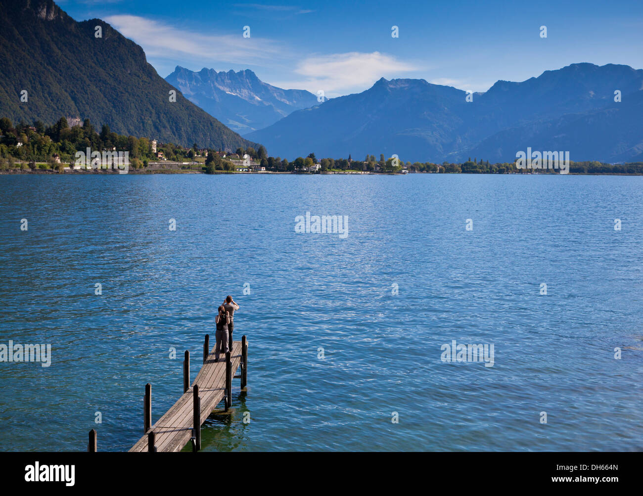 Scattare foto sul molo dal Castello di Chillon a Montreux affacciato sul Lago di Ginevra e sulle vicine montagne Foto Stock