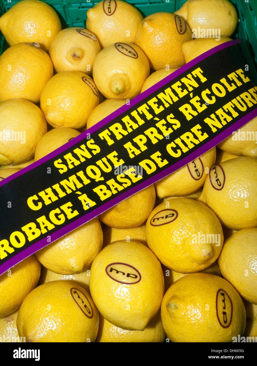 Cassa di limoni non trattati con banner di avviso - Francia. Foto Stock