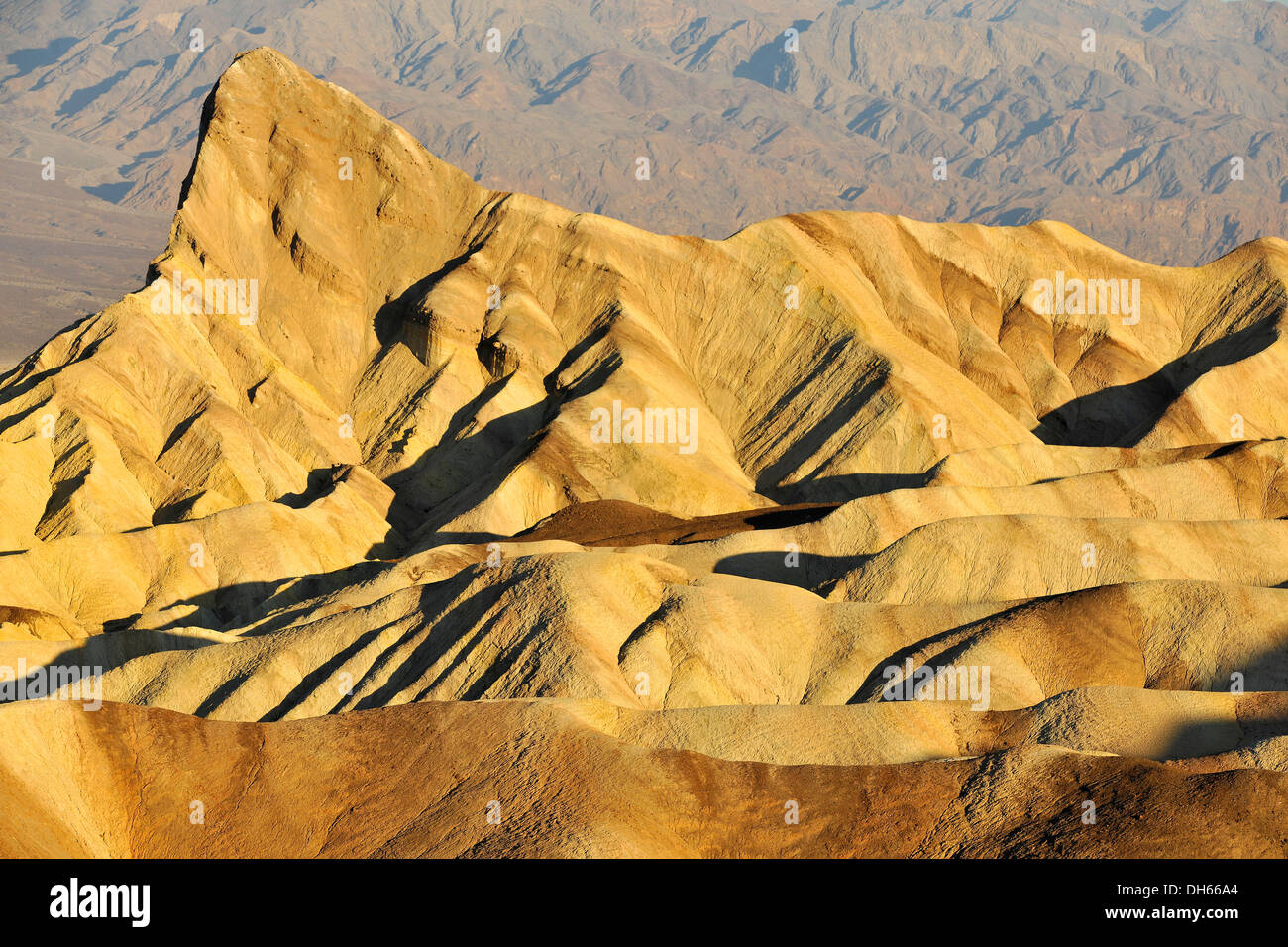 Vista da Zabriskie Point over eroso le formazioni rocciose di Manly Beacon scolorito da minerali, Panamint Gamma nella parte posteriore Foto Stock
