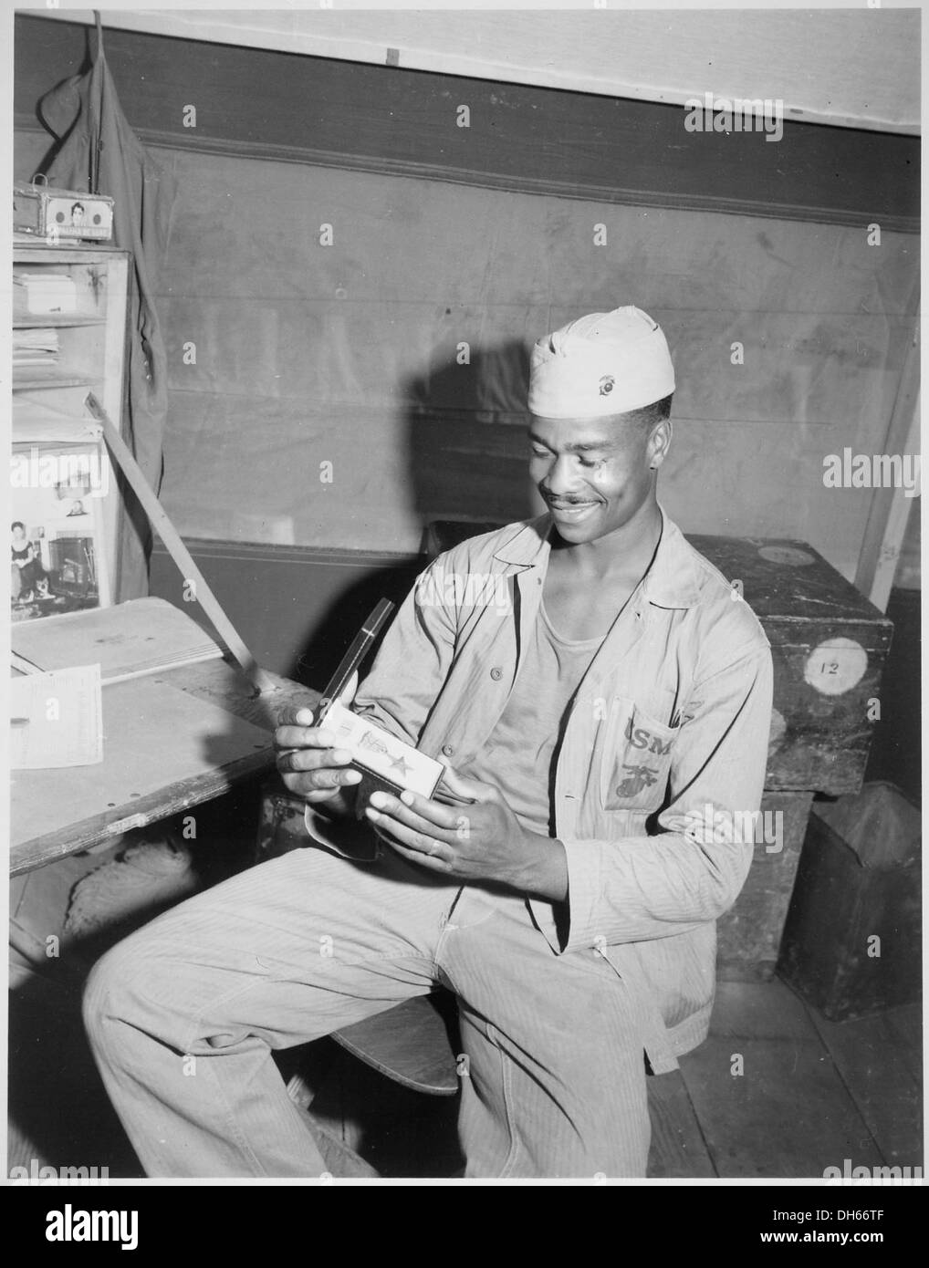 Luther Woodward, membro della Fourth Ammunition Company, ammira la Stella di bronzo che gli è stata assegnata per il suo coraggio e il suo servizio. La fotografia cattura un momento orgoglioso di riconoscimento militare. Foto Stock