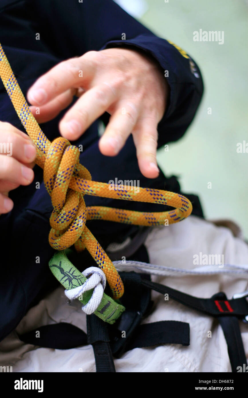 Top-corda scalatore nel Kletterzentrum Amburgo centro di arrampicata stesso vincolanti per l'ascensione e attaccare la fune di sicurezza Foto Stock