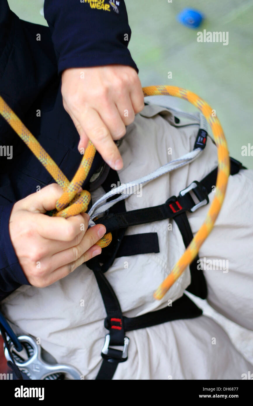 Top-corda scalatore nel Kletterzentrum Amburgo centro di arrampicata stesso vincolanti per l'ascensione e attaccare la fune di sicurezza Foto Stock