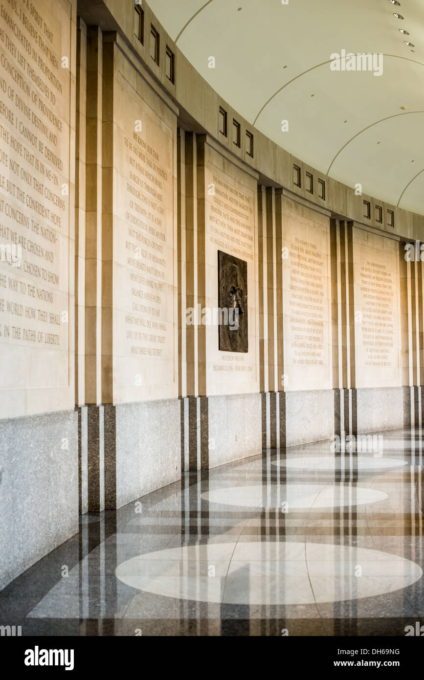 Woodrow Wilson Memorial Hallway Washington DC | WASHINGTON D.C., Stati Uniti — citazioni da Woodrow Wilson line un corridoio curvo presso il Woodrow Wilson International Center for Scholars, il memoriale ufficiale della nazione al 28 ° presidente. Il Congresso istituì il centro nel 1968 come "memoriale vivente", favorendo un'istituzione accademica in corso rispetto a una statua o monumento tradizionale. Un ritratto in bronzo di Wilson segna la parete calcarea incisa tra i passaggi tratti dai suoi discorsi. Foto Stock