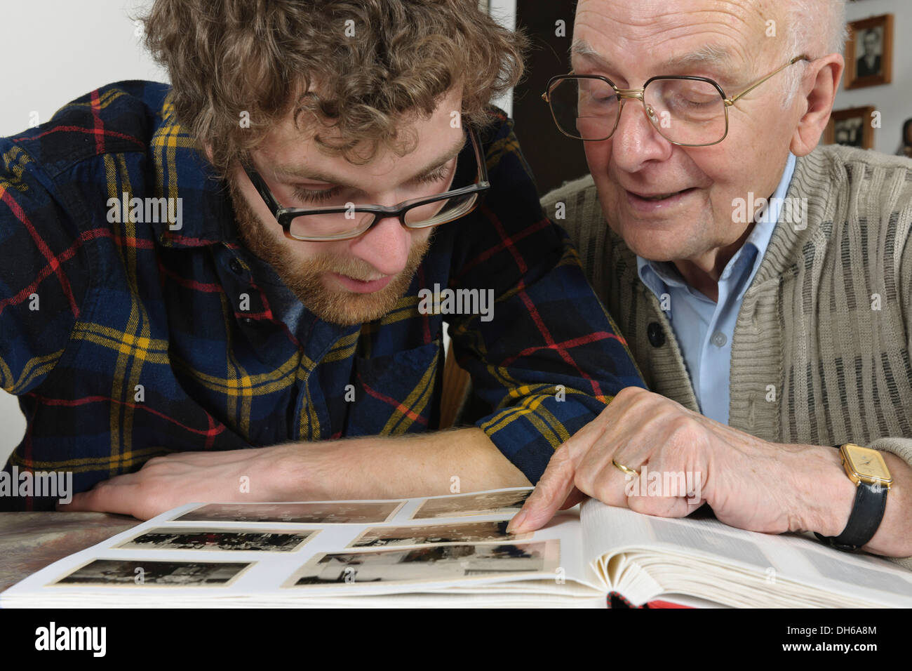 Nipote e nonno guardando le foto in un album di foto, Emmendingen, Baden-Württemberg, Germania Foto Stock