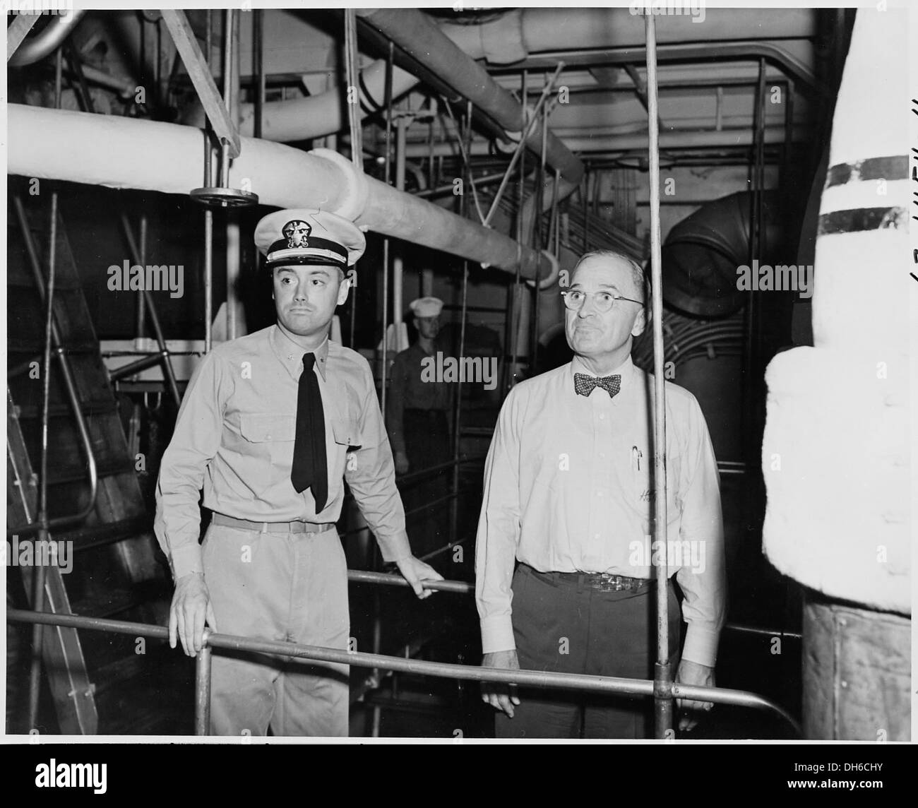 Tenente comandante N. V. King, ufficiale di ingegneria, accompagna il presidente Harry S. Truman attraverso la sala macchine, facendo un tour. La foto cattura un momento durante il tour presidenziale di Truman. Foto Stock