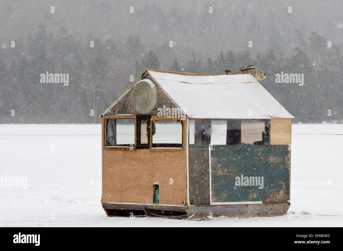 Un ampio e verde per la pesca nel ghiaccio shack in una tempesta di neve. Foto Stock