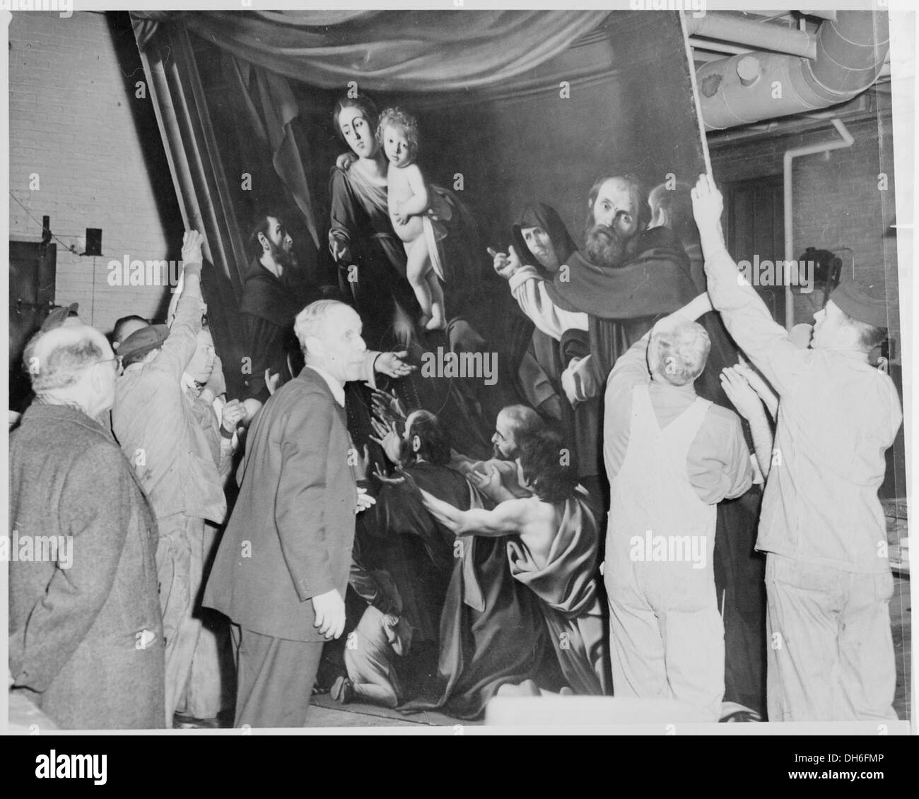 Gli operai del Metropolitan Museum of Art di New York sono visti sradicare "la Madonna dei Rosari", un rinomato dipinto dell'artista italiano Caravaggio. L'opera d'arte viene gestita con cura per essere esposta nel museo. Foto Stock