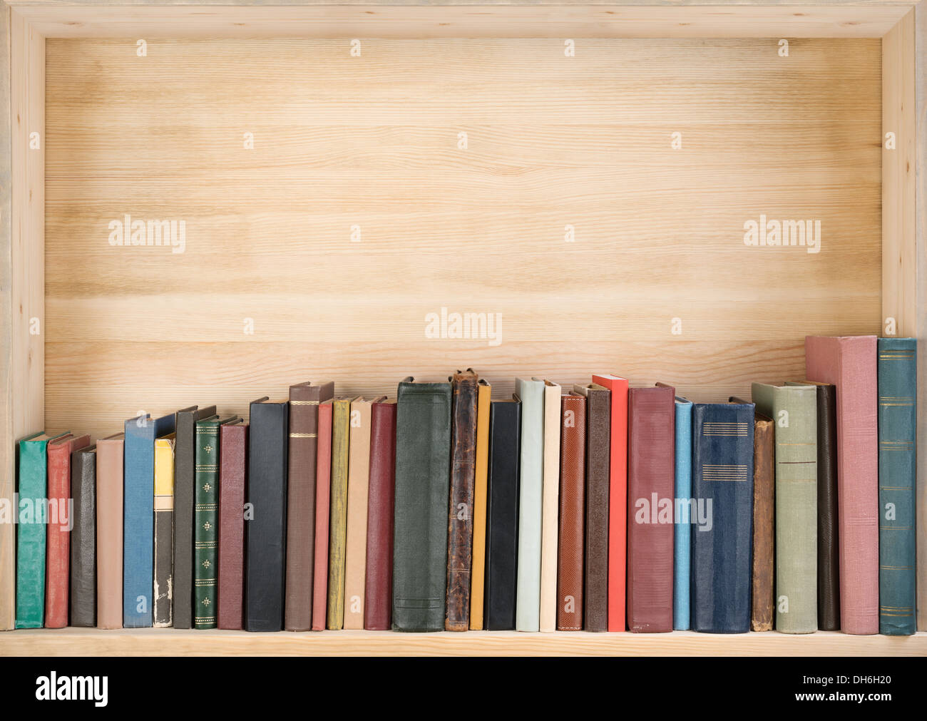 Vecchi libri su uno scaffale di legno. Foto Stock