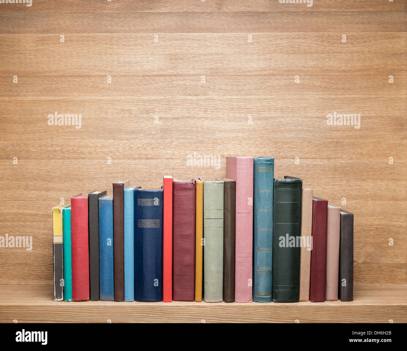 Vecchi libri su uno scaffale di legno. Foto Stock