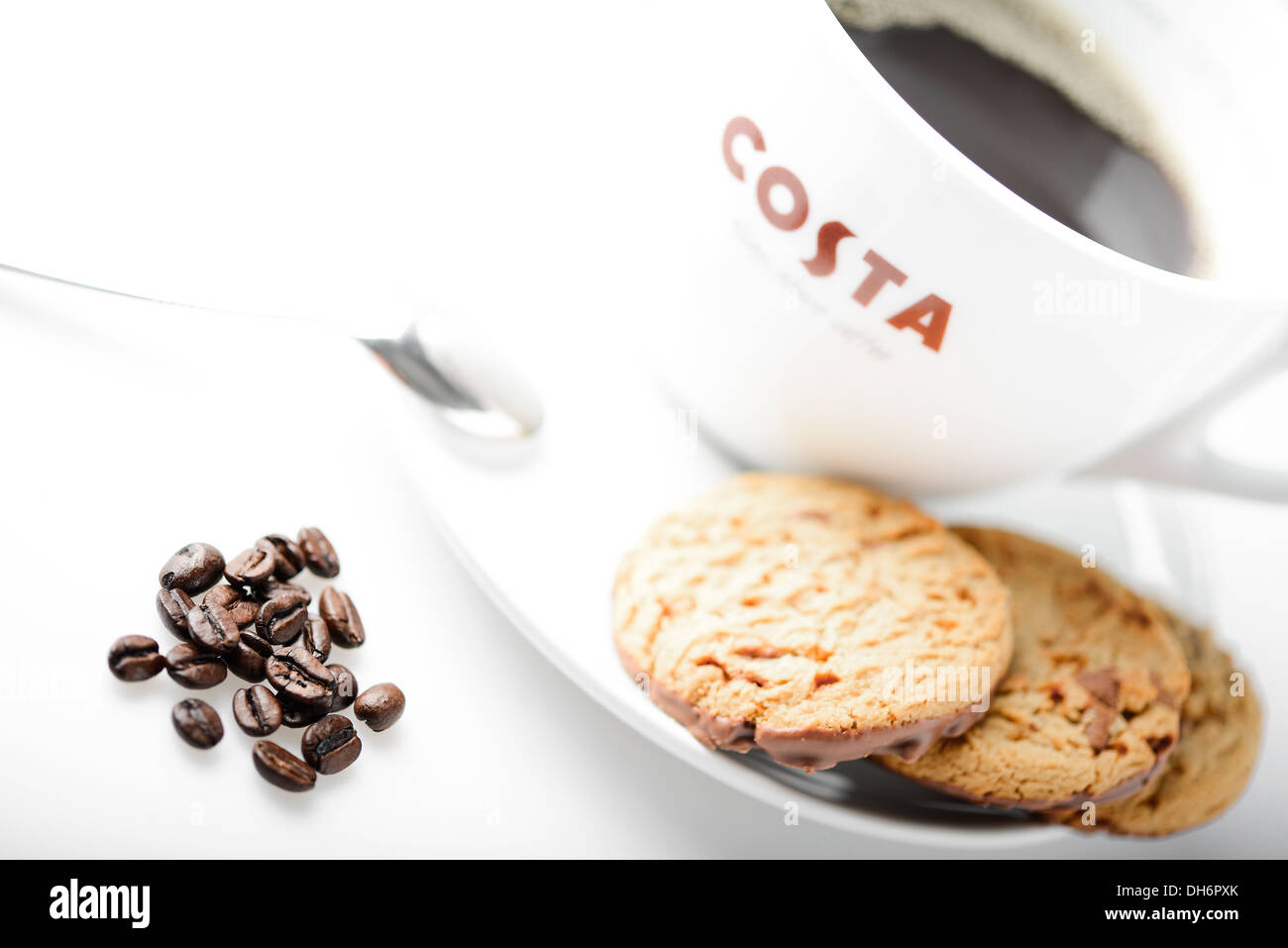 Tazza di caffè Costa con choc chip cookie e i chicchi di caffè sul tavolo Foto Stock