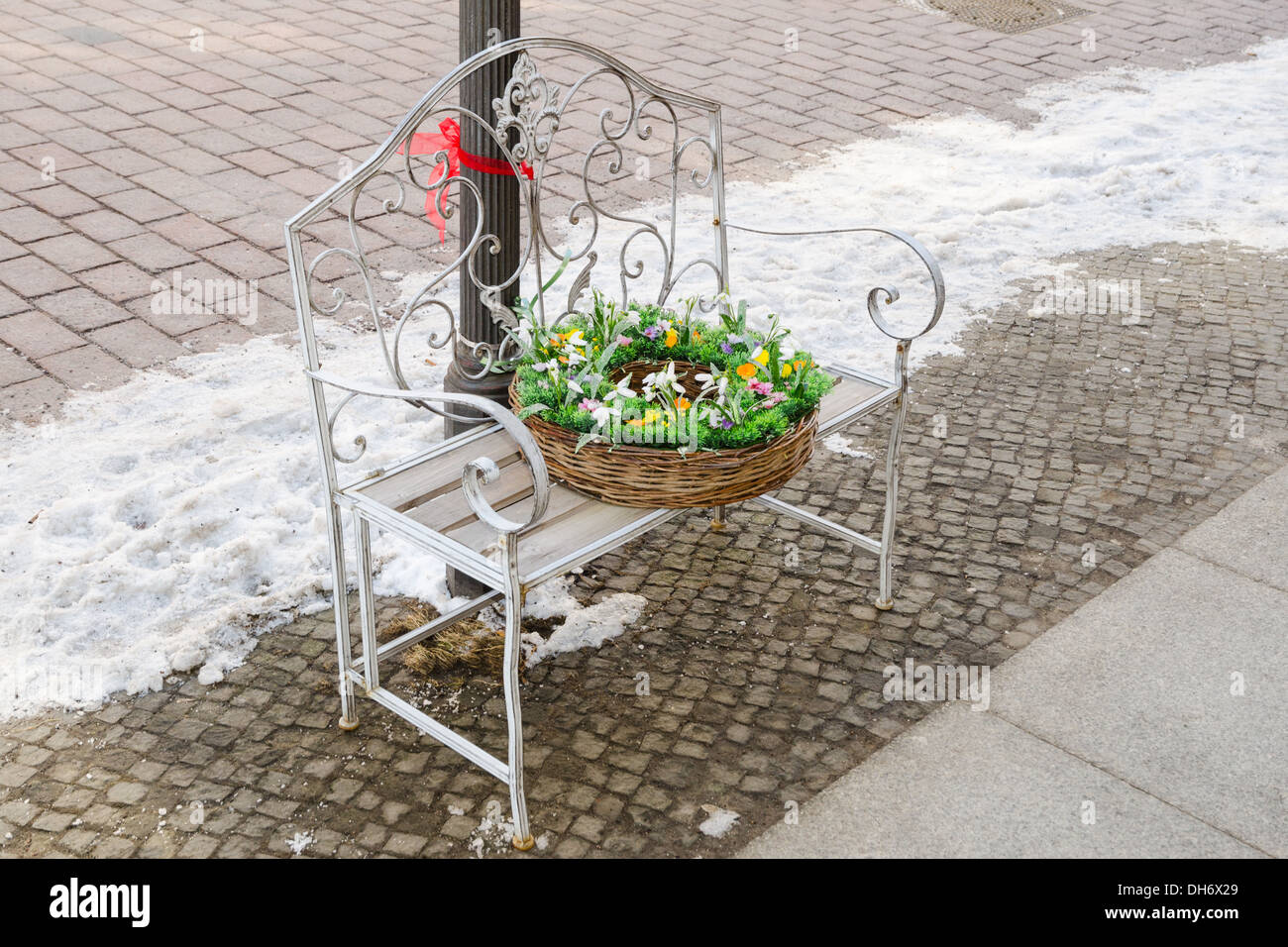 Cesto in Vimini con fiori di primavera sul ferro battuto panchina Foto Stock