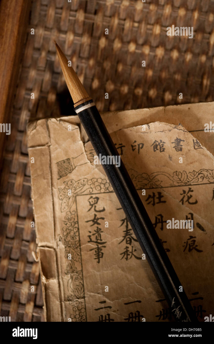 Inchiostro Cinese pennello e un vecchio libro Foto Stock
