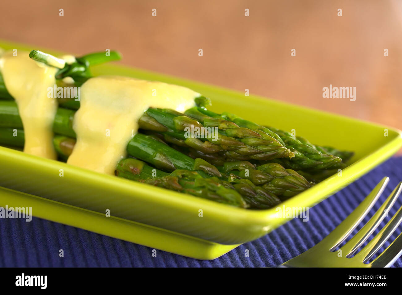 Cuocere gli asparagi verdi con salsa olandese sulla parte superiore (il fuoco selettivo, Focus sulla punta di asparagi in alto) Foto Stock