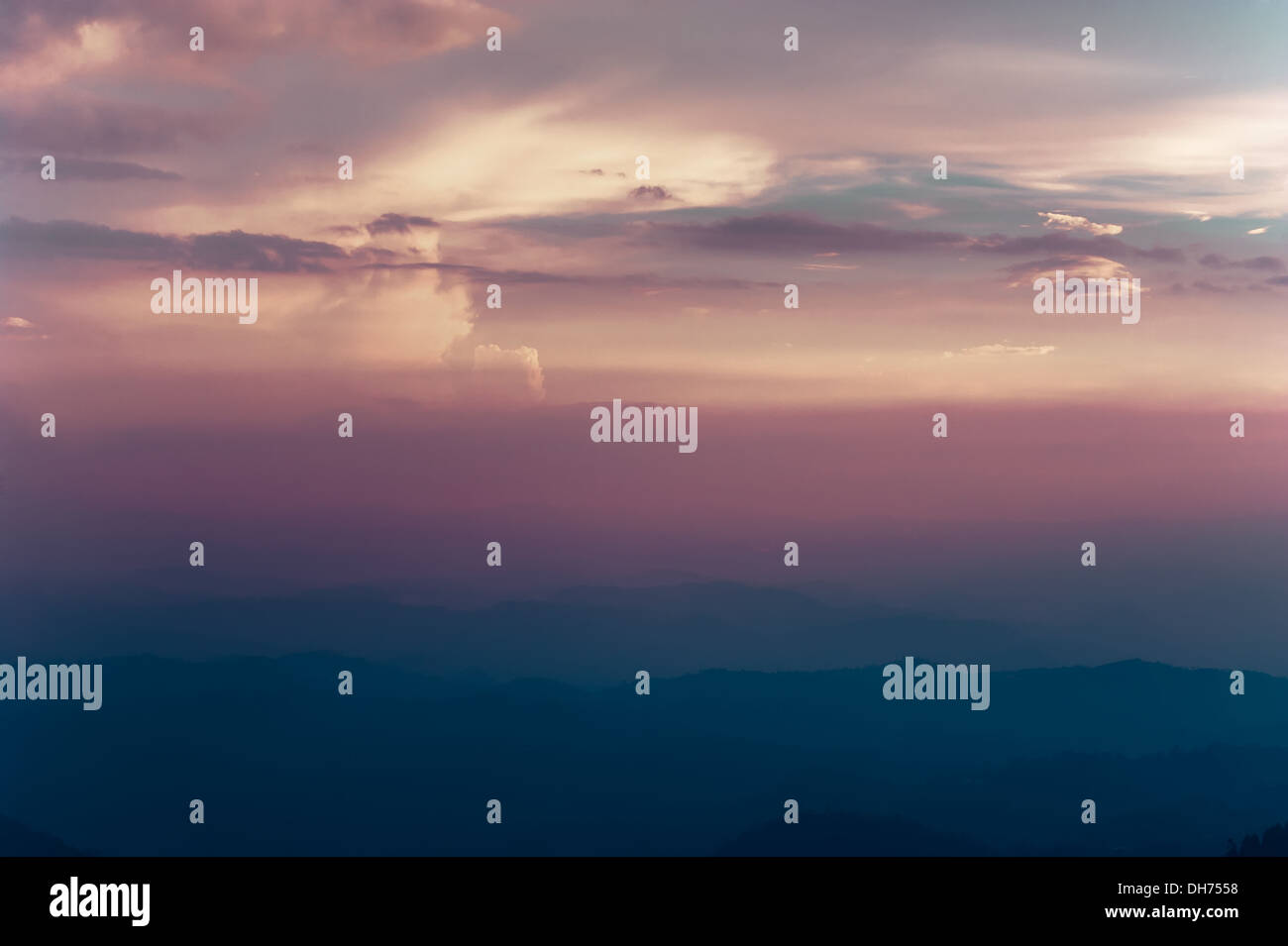 Bellissimo Cielo di tramonto colori con drammatica nuvole e Misty Mountains silhouette. India del sud paesaggio. Munnar Kerala, India Foto Stock