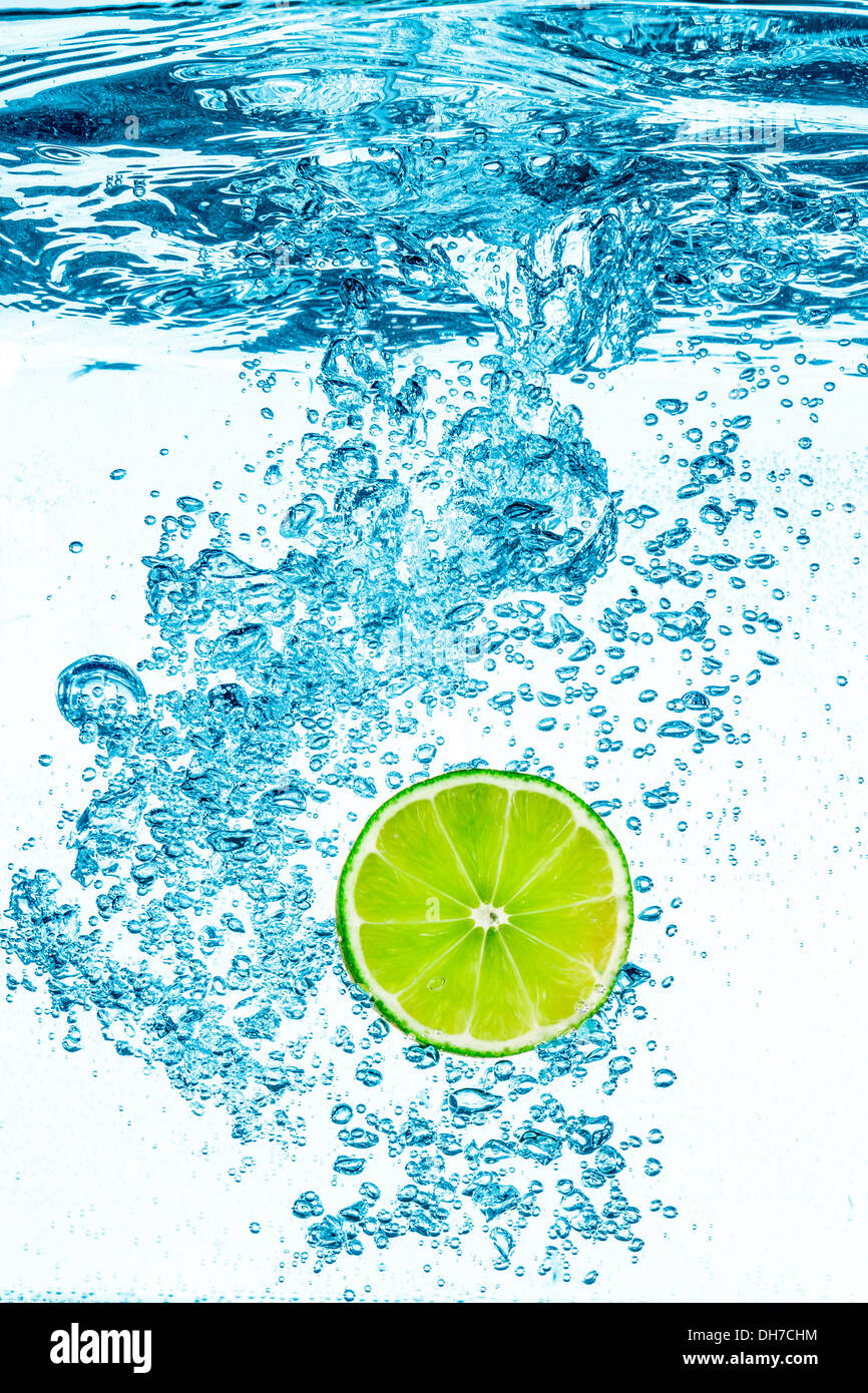 Fresco e verde lime in acqua chiara su sfondo bianco. Foto Stock