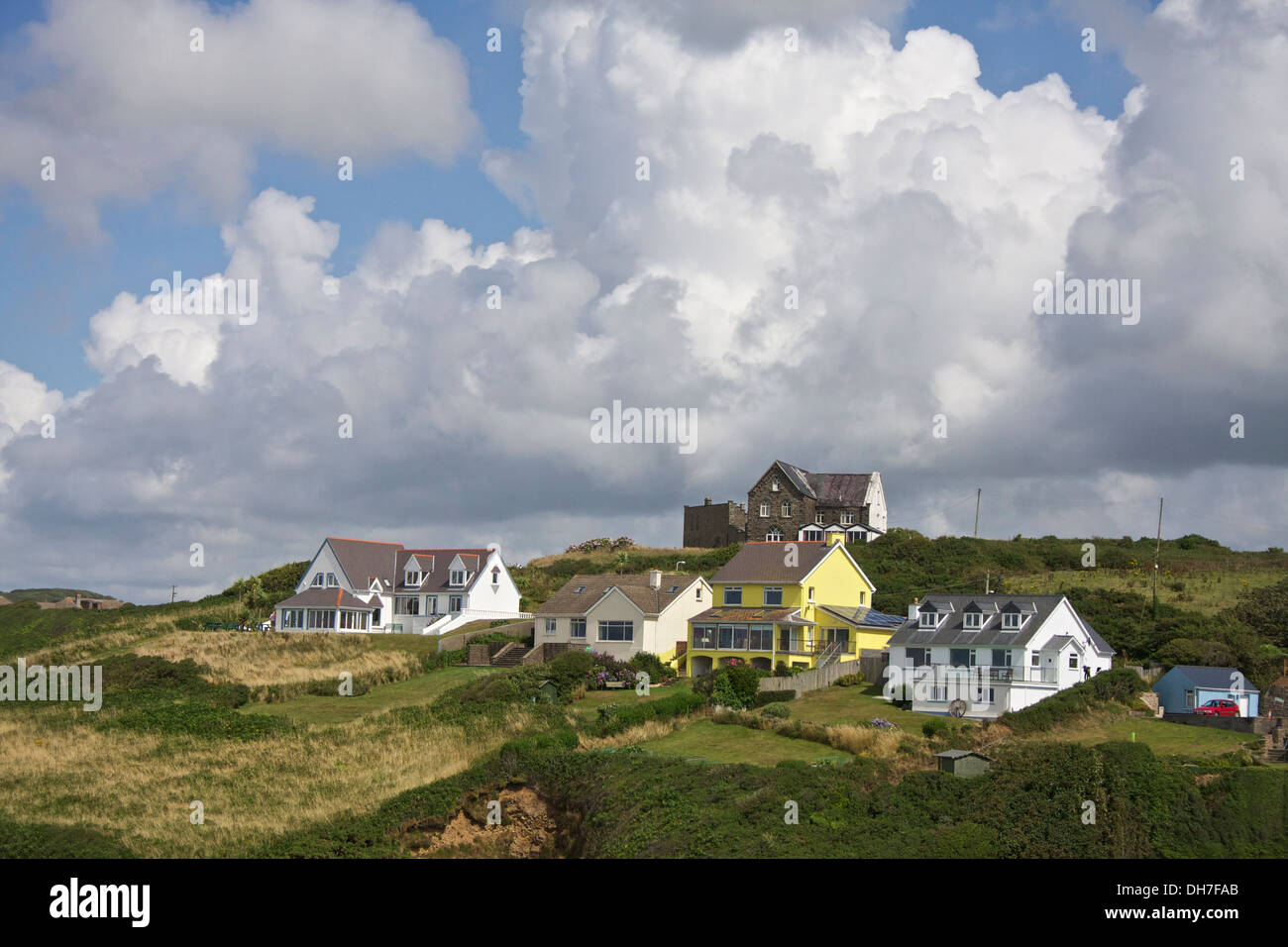 Drammatica formazione delle nuvole sopra il gallese case di villaggio su una collina. Foto Stock