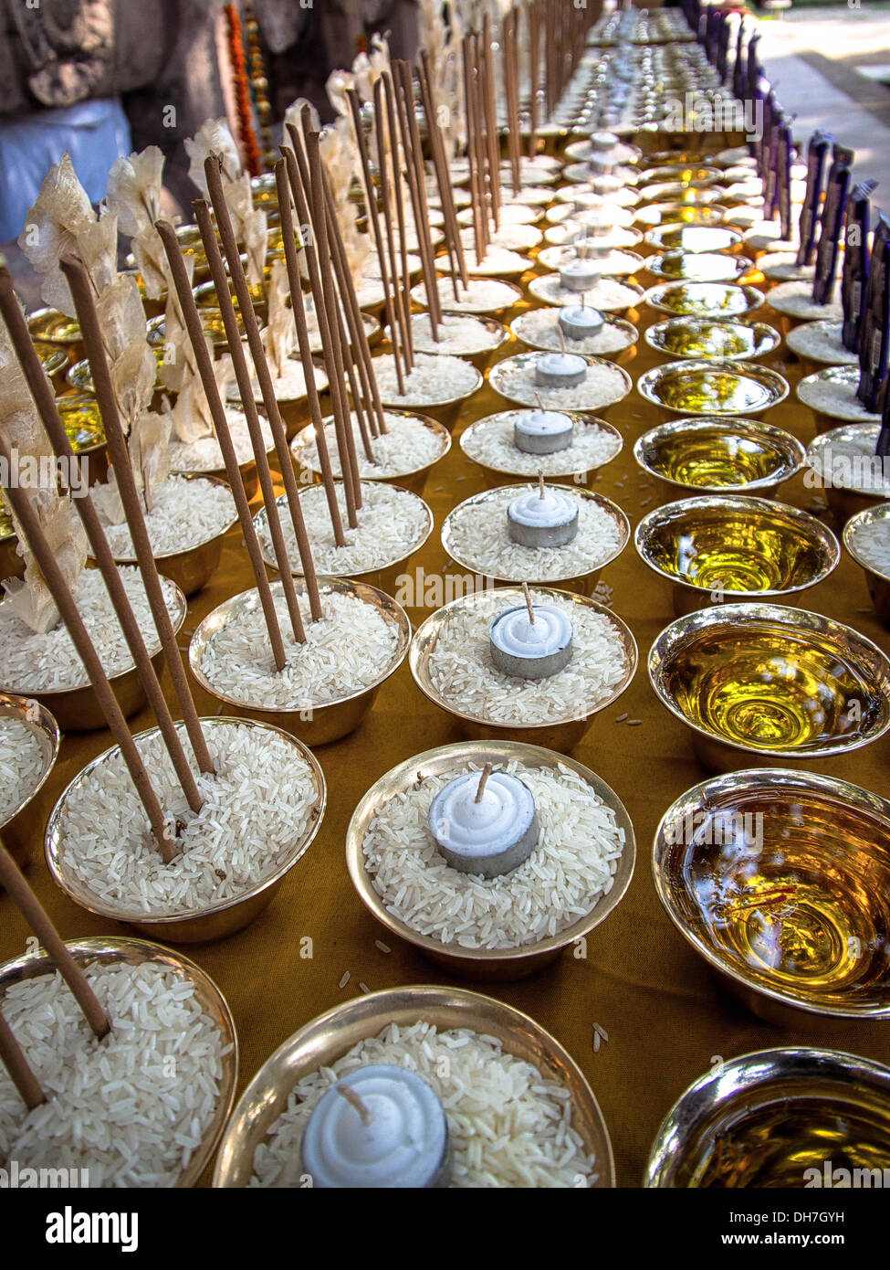 Candele, incenso, riso e barrette di cioccolato schierate come cerimoniale di offerte presso il tempio di Mahabodhi a Bodhgaya,, India. Foto Stock