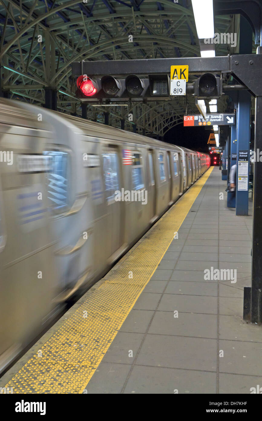 Un treno della metropolitana in movimento come si arriva a Stillwell Avenue Station in notturna a Coney Island, Brooklyn Foto Stock