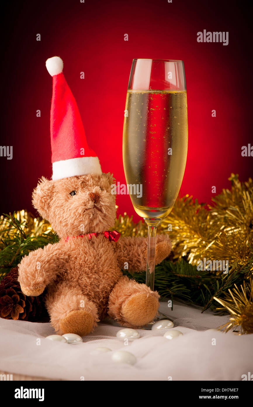 Orso di peluche con un bicchiere di spumante sulla decorazione di Natale sfondo Foto Stock