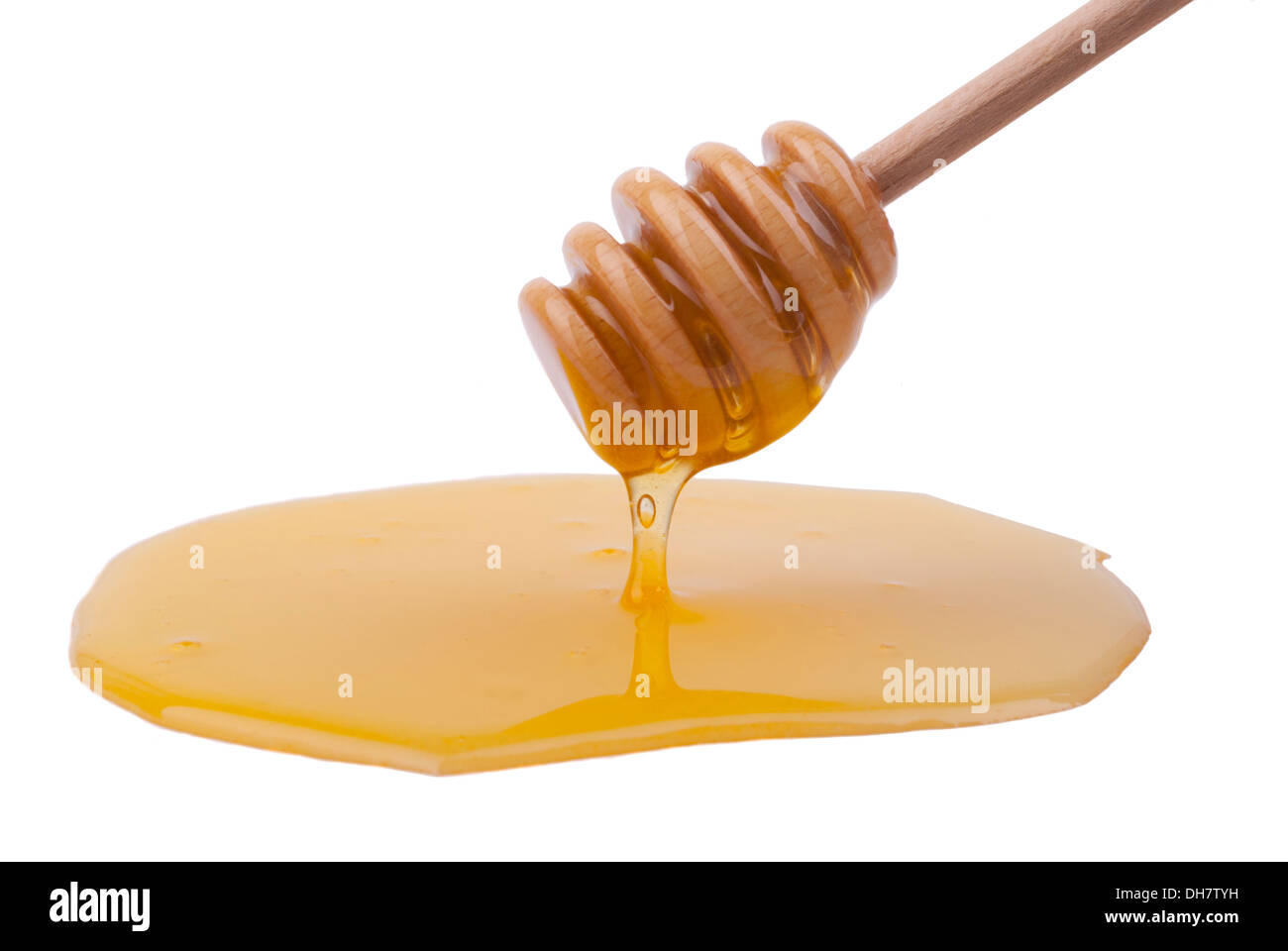 Il miele il gocciolamento da un cucchiaio di legno. Foto Stock
