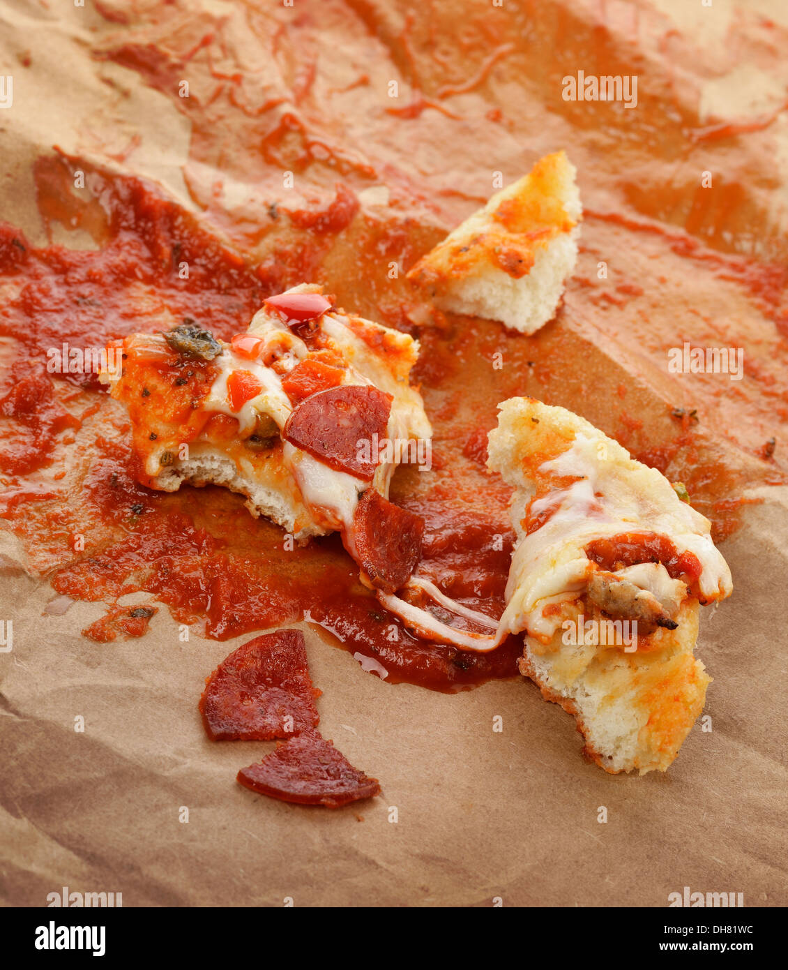 Avanzi di Pizza sulla carta con salsa di pomodoro Foto Stock
