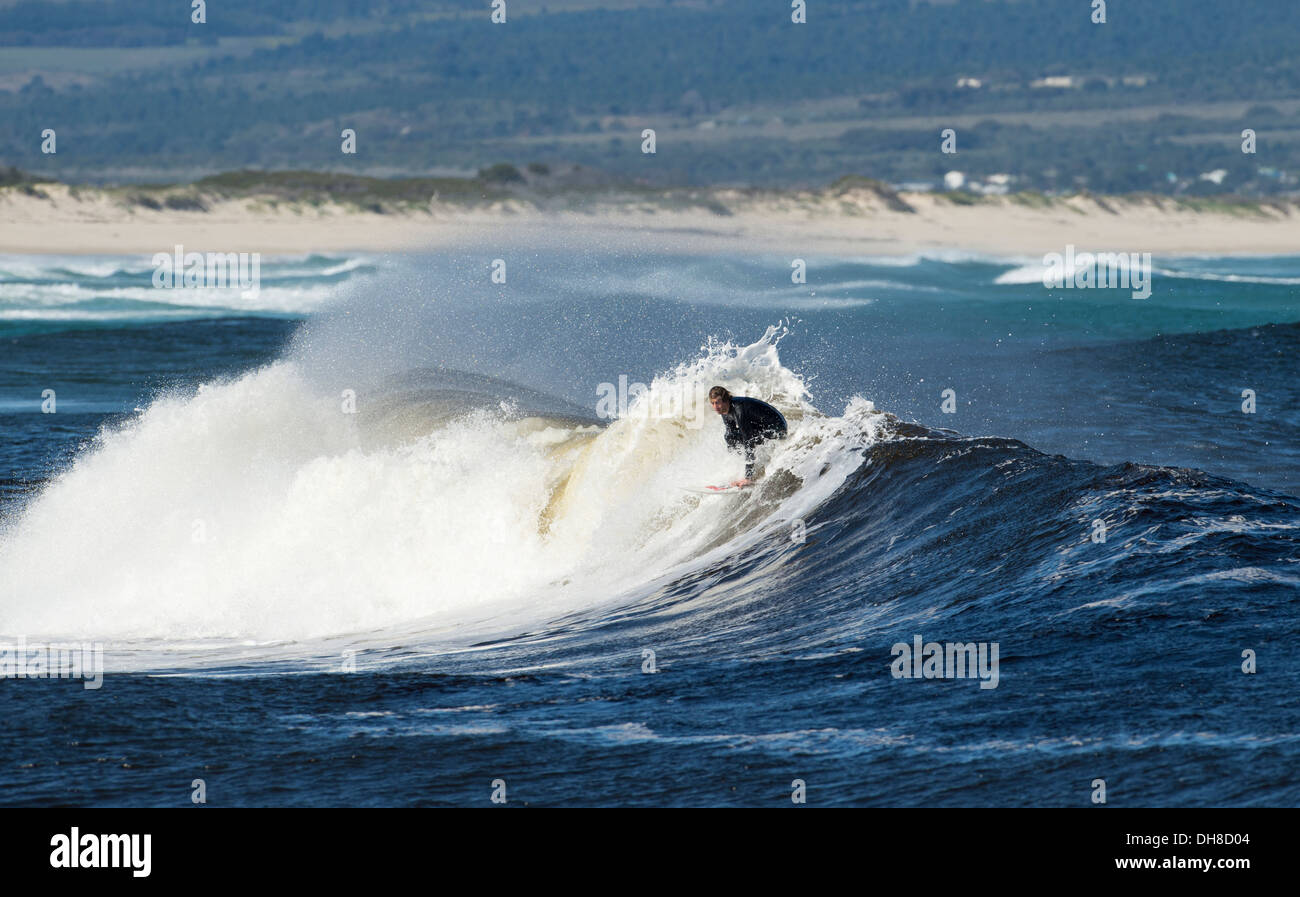 Surfer cavalcando le onde, labbro diapositiva, Western Cape, Sud Africa Foto Stock