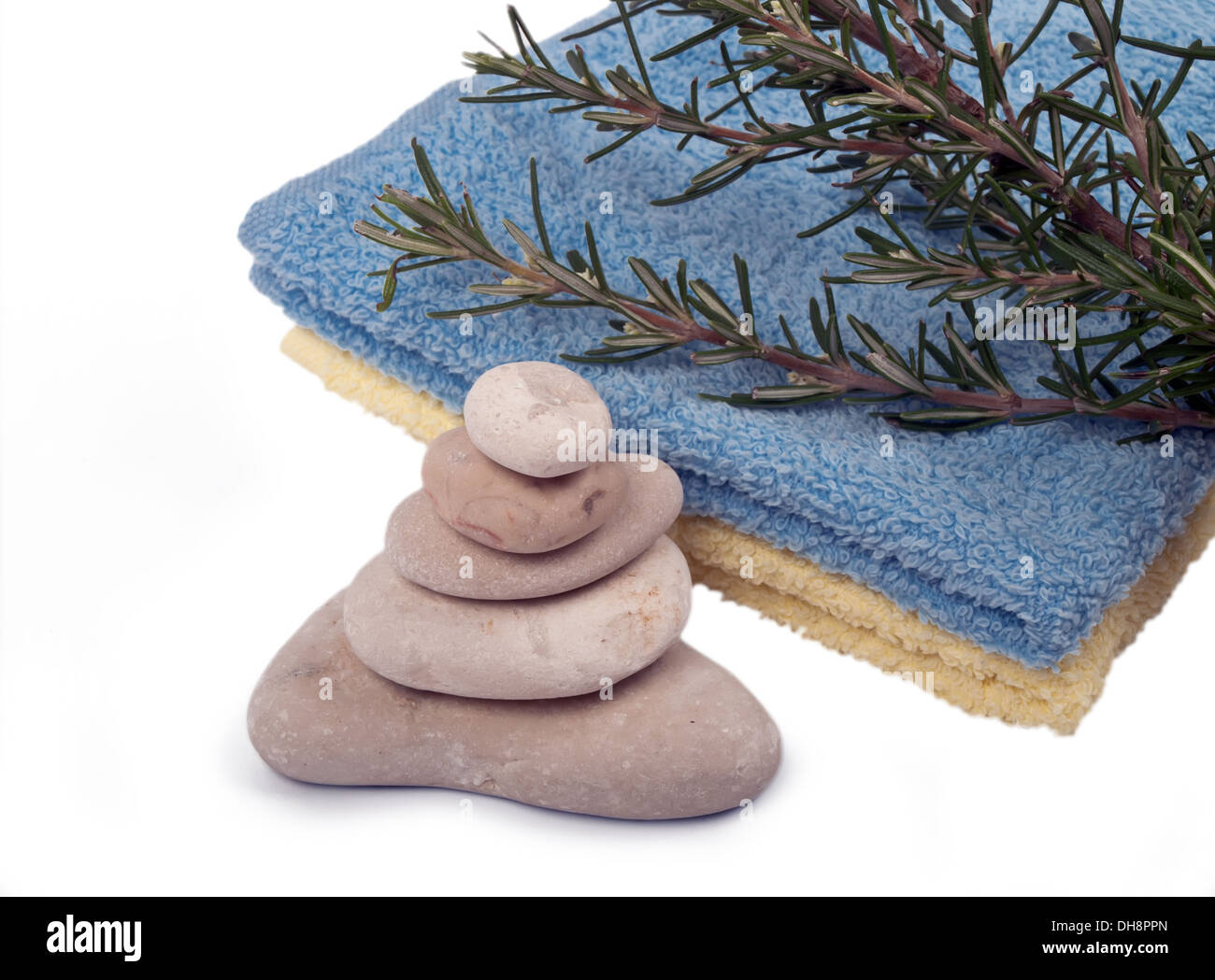 Equilibrato pietre di mare, asciugamani e rosmarino Foto Stock