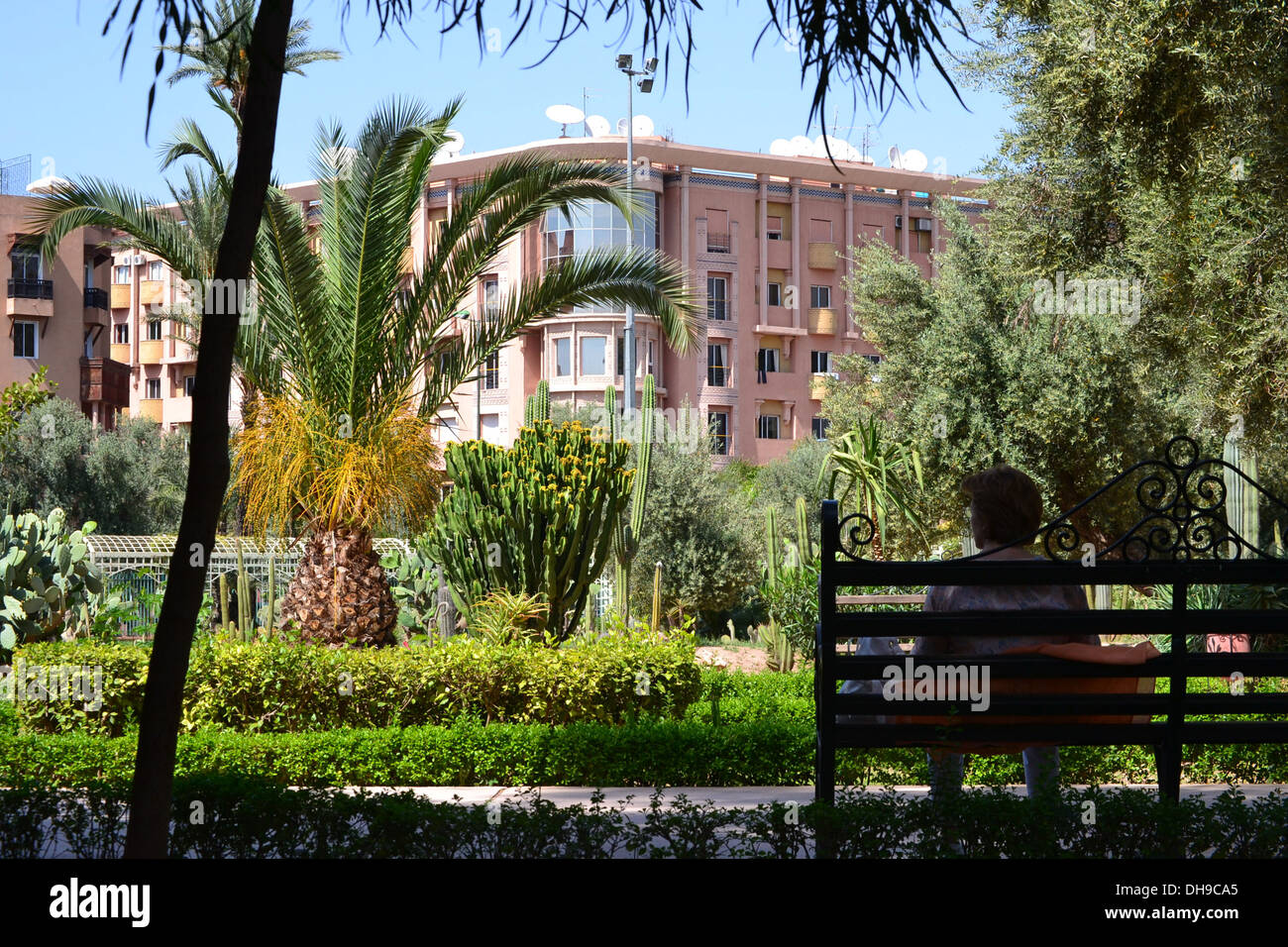 Signora seduta sulla panchina nel parco in Marrakech, Marocco. Foto Stock