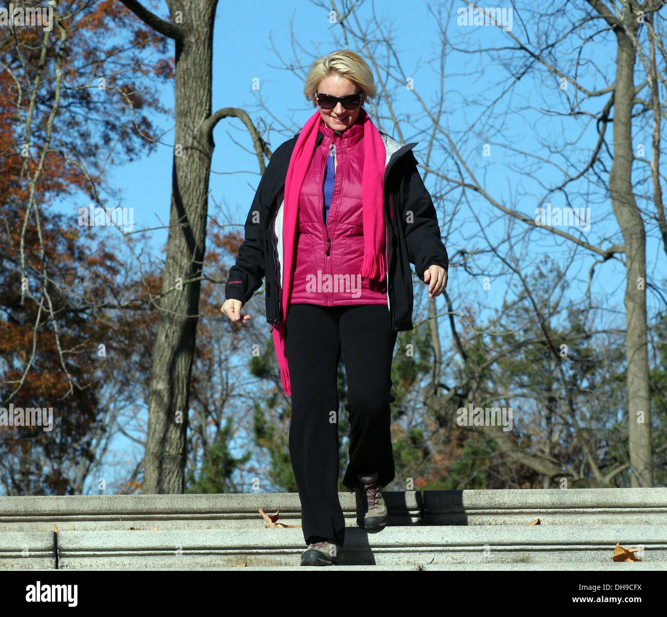 Giovane donna bionda scendendo alcuni outdoor di gradini di pietra. Foto Stock