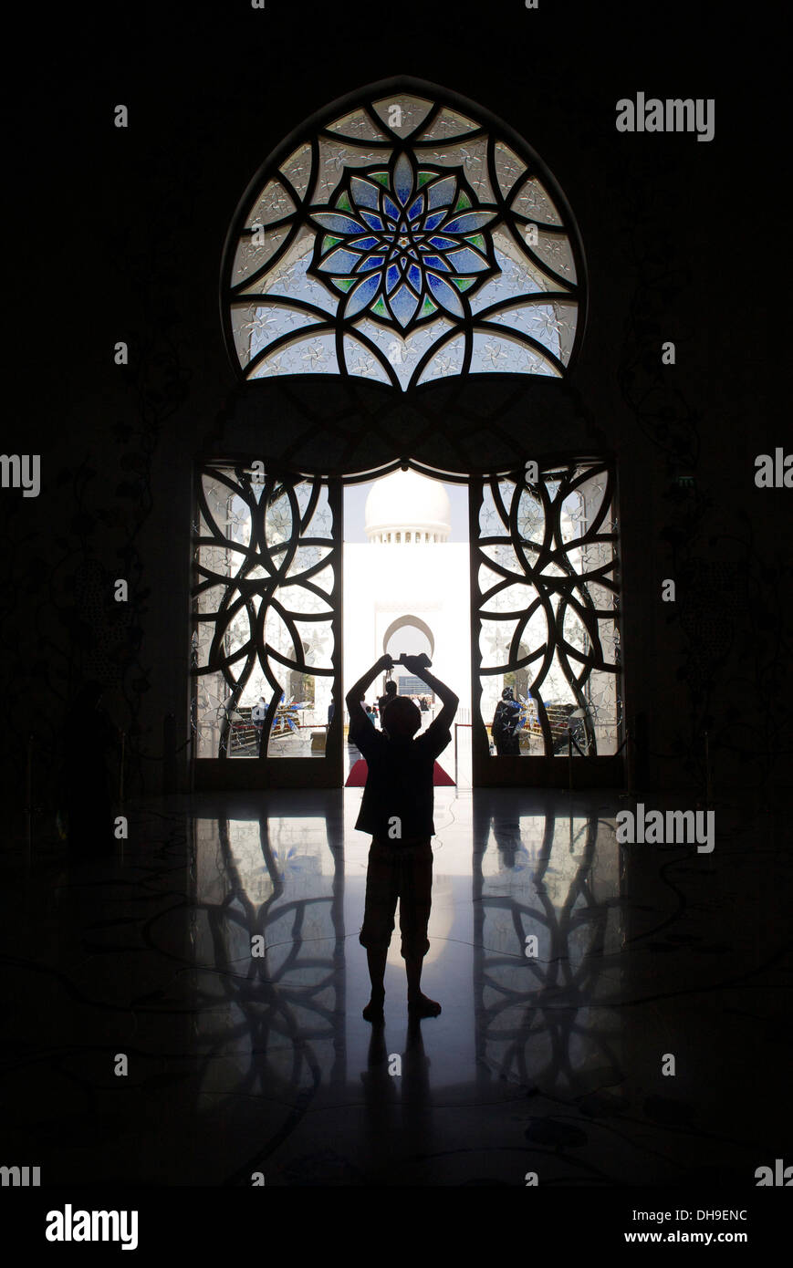 Un giovane turista scatta una fotografia all'interno della Sheikh Zayed Grande Moschea di Abu Dhabi, Emirati arabi uniti Foto Stock