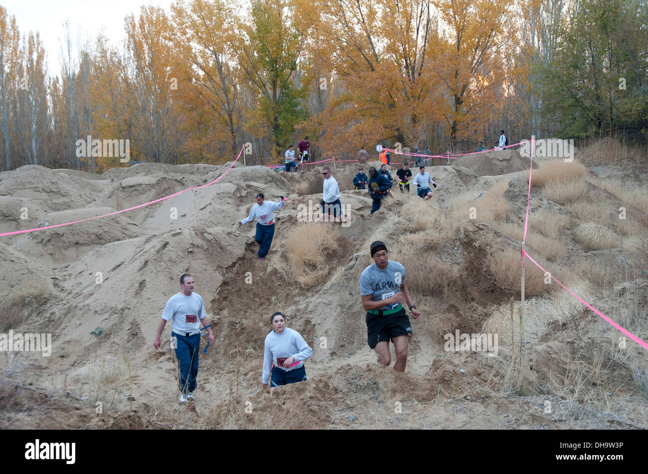Militari membri navigare attraverso vari ostacoli nella foresta Frunze durante un 'zombie run" al Centro di Transito di Manas, Kirghizistan, il 31 ottobre 2013. L'evento volontari disponibili a giocare i ruoli di esecuzione di zombie, passeggiate zombie e gli esseri umani cercano di ottenere Foto Stock