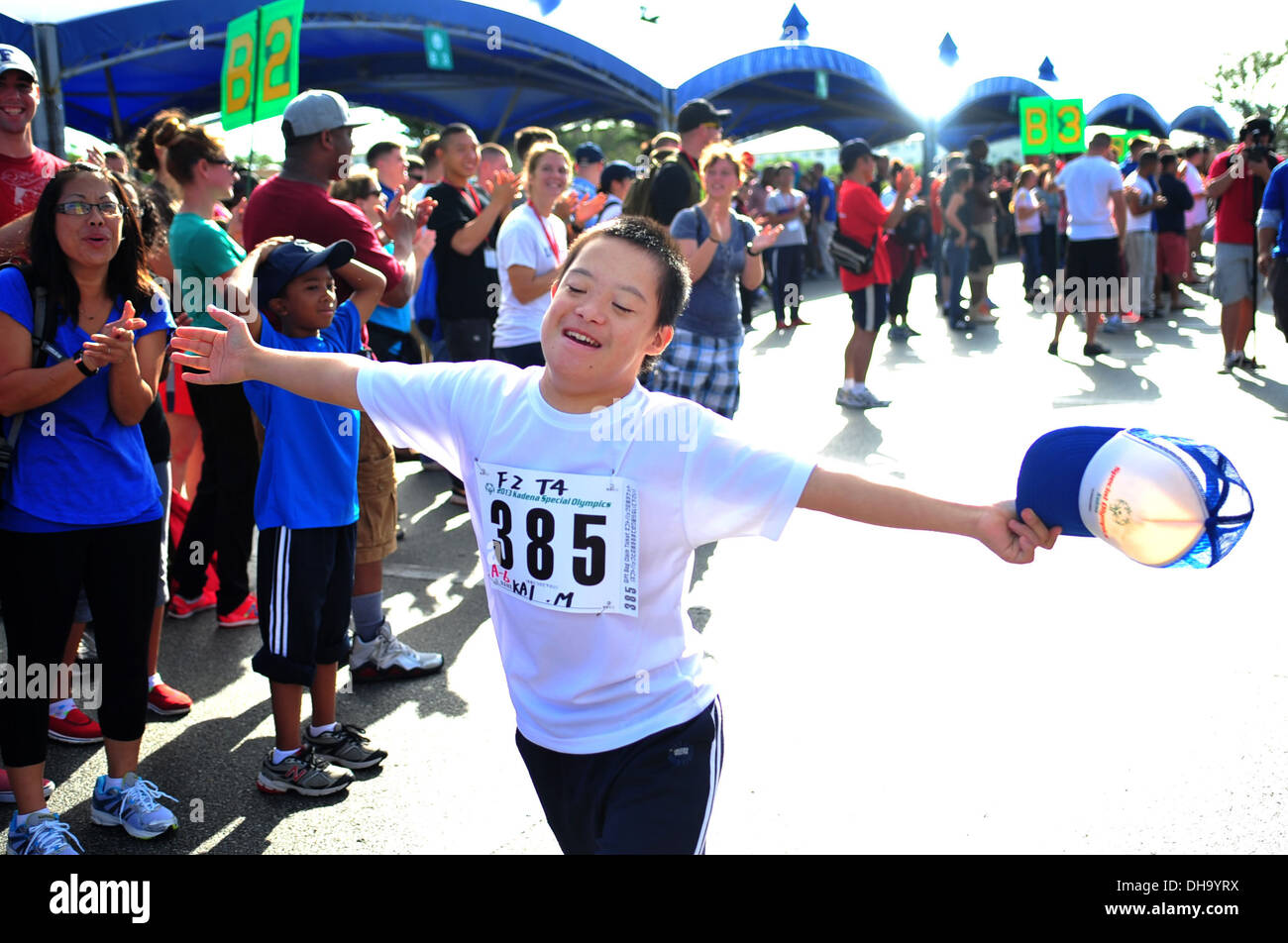 Kai Minatogawa, 13 anni, corre lungo una fila di cheerers durante la Kadena Olimpiadi speciali su Kadena Air Base, Giappone, nov. 2, Foto Stock