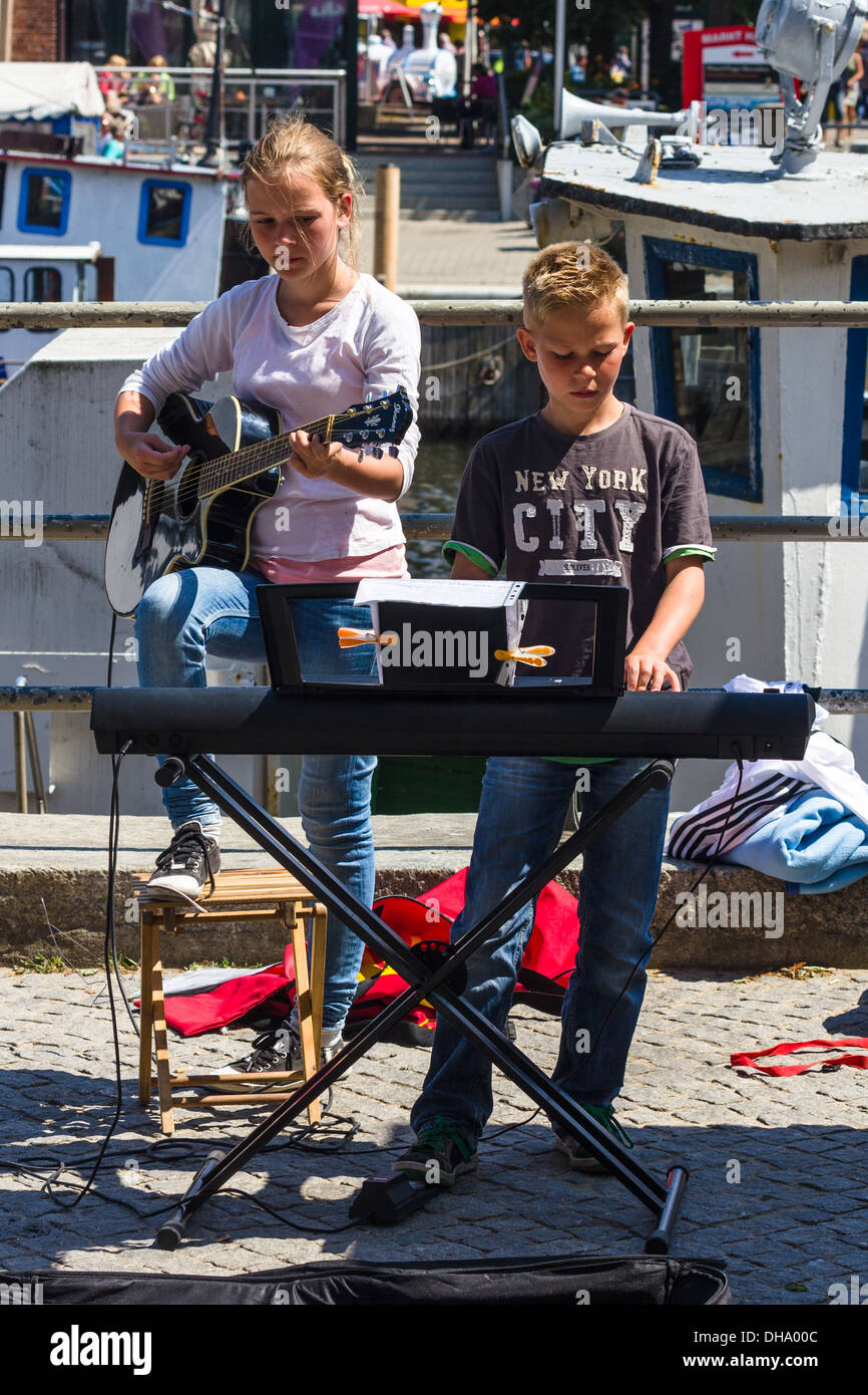 Bambini giovani suonare strumenti musicali, musicista di strada sul lungomare di Warnemunde Rostock Germania. Foto Stock