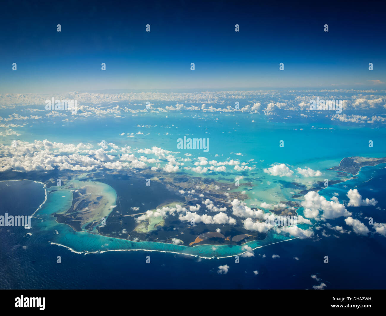 Vista aerea di colorate catene di isole tropicali con barriere coralline, sandbar, pali di sale e nuvole Foto Stock