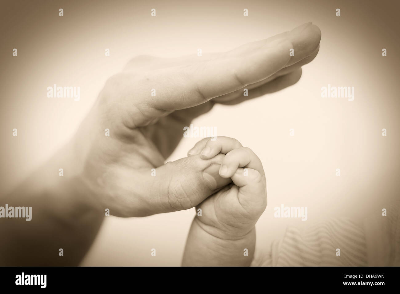 Concetto di amore e famiglia. Mani di madre e bambino closeup Foto Stock