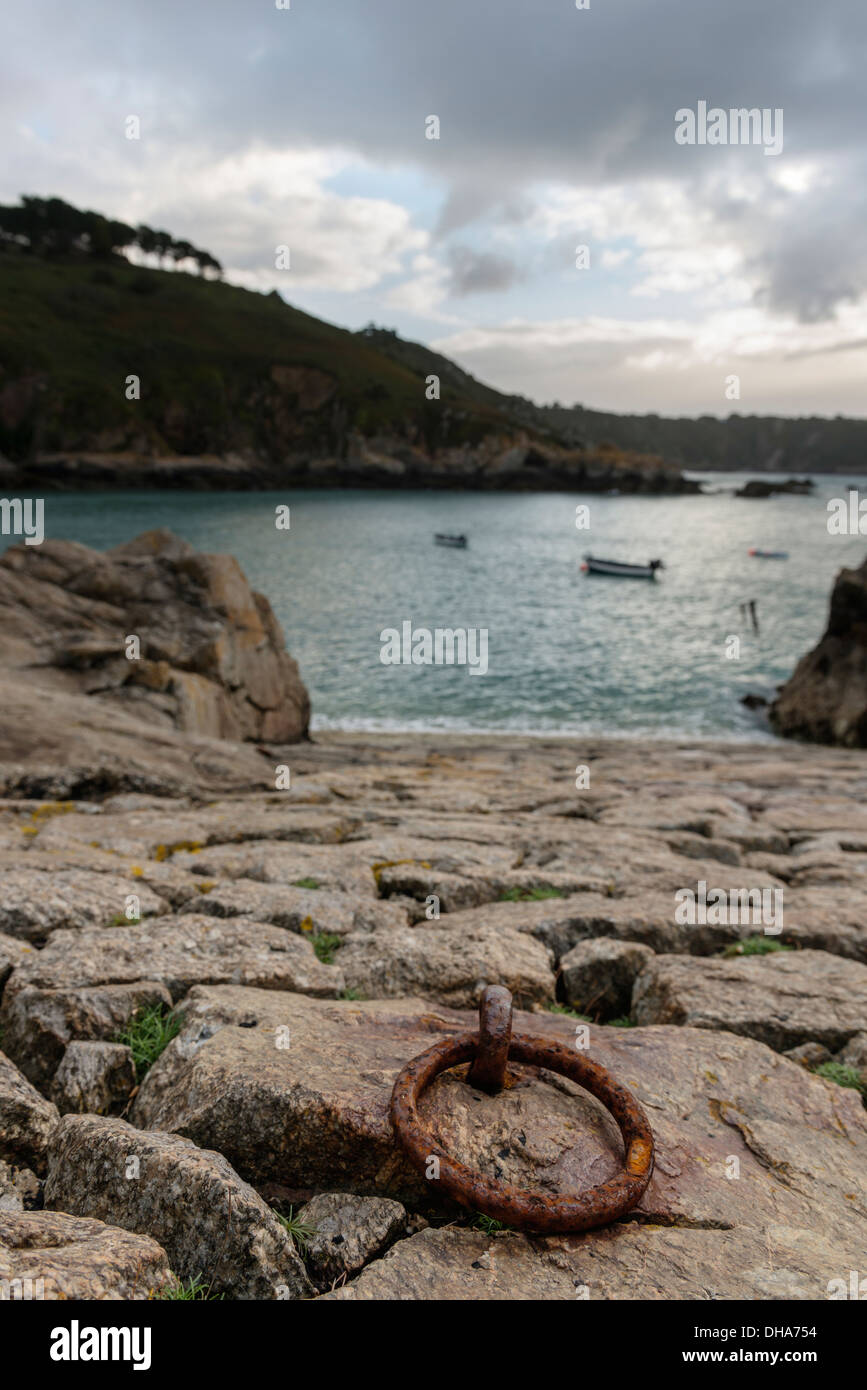 Di ferro arrugginito anello di ormeggio sulla pietra di uno scalo All Saints Bay Harbor, Guernsey, Isole del Canale. Foto Stock
