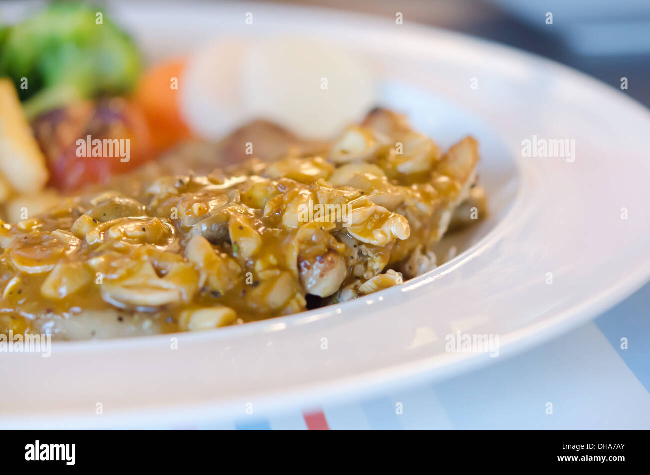 Close up bistecca di manzo con salsa di funghi servita con patatine e verdure Foto Stock