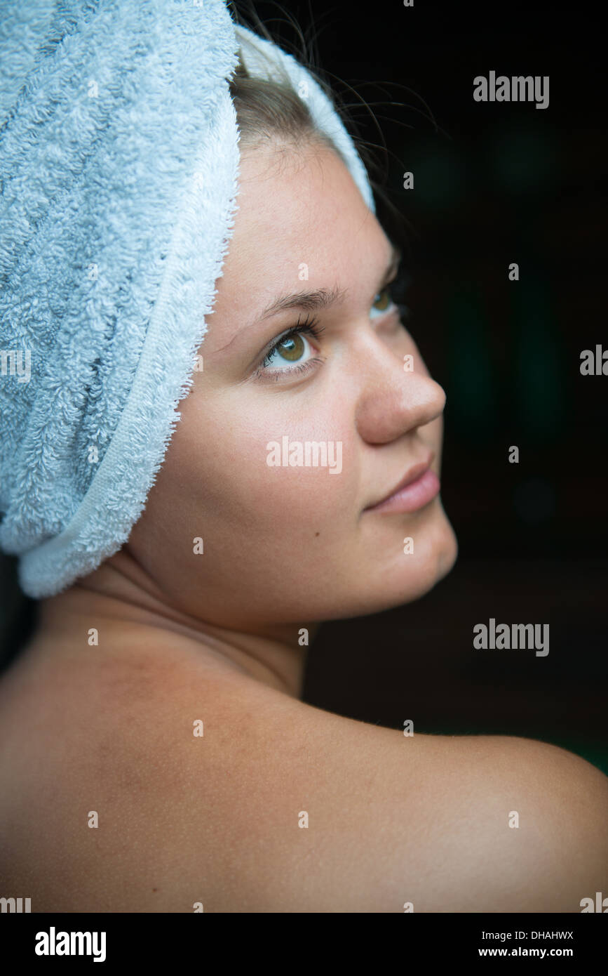 Profilo di giovane donna con asciugamano avvolto attorno alla sua testa dopo tenendo bagno Foto Stock