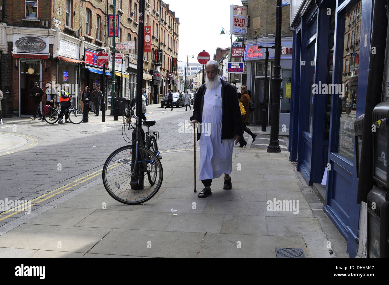 Un uomo asiatico passeggiate in Brick Lane, Londra Foto Stock