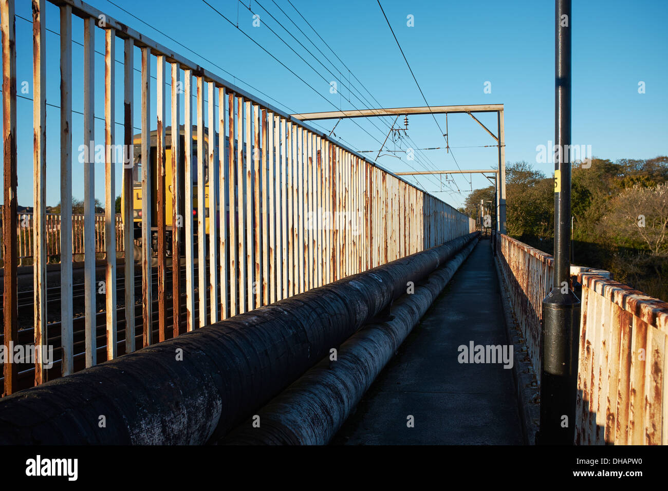 Sentiero pedonale in esecuzione accanto alla stazione sul ponte che attraversa il fiume Lune in Lancaster City Centre Regno Unito Foto Stock
