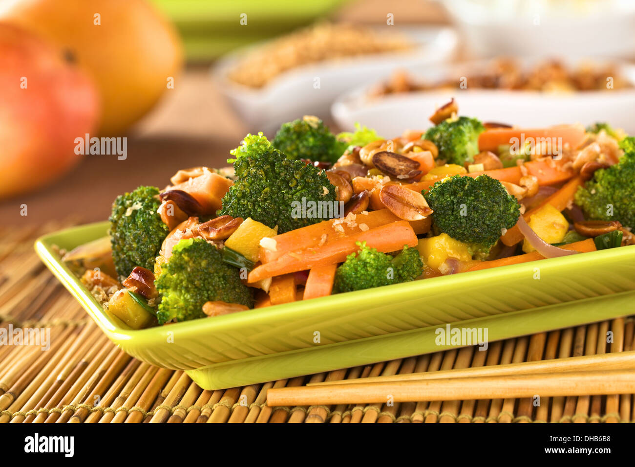 Vegetariano friggere in stile Thailandese con broccoli, carota, cipolla, mango con patatine fritte di scaglie di cocco e arachidi Foto Stock