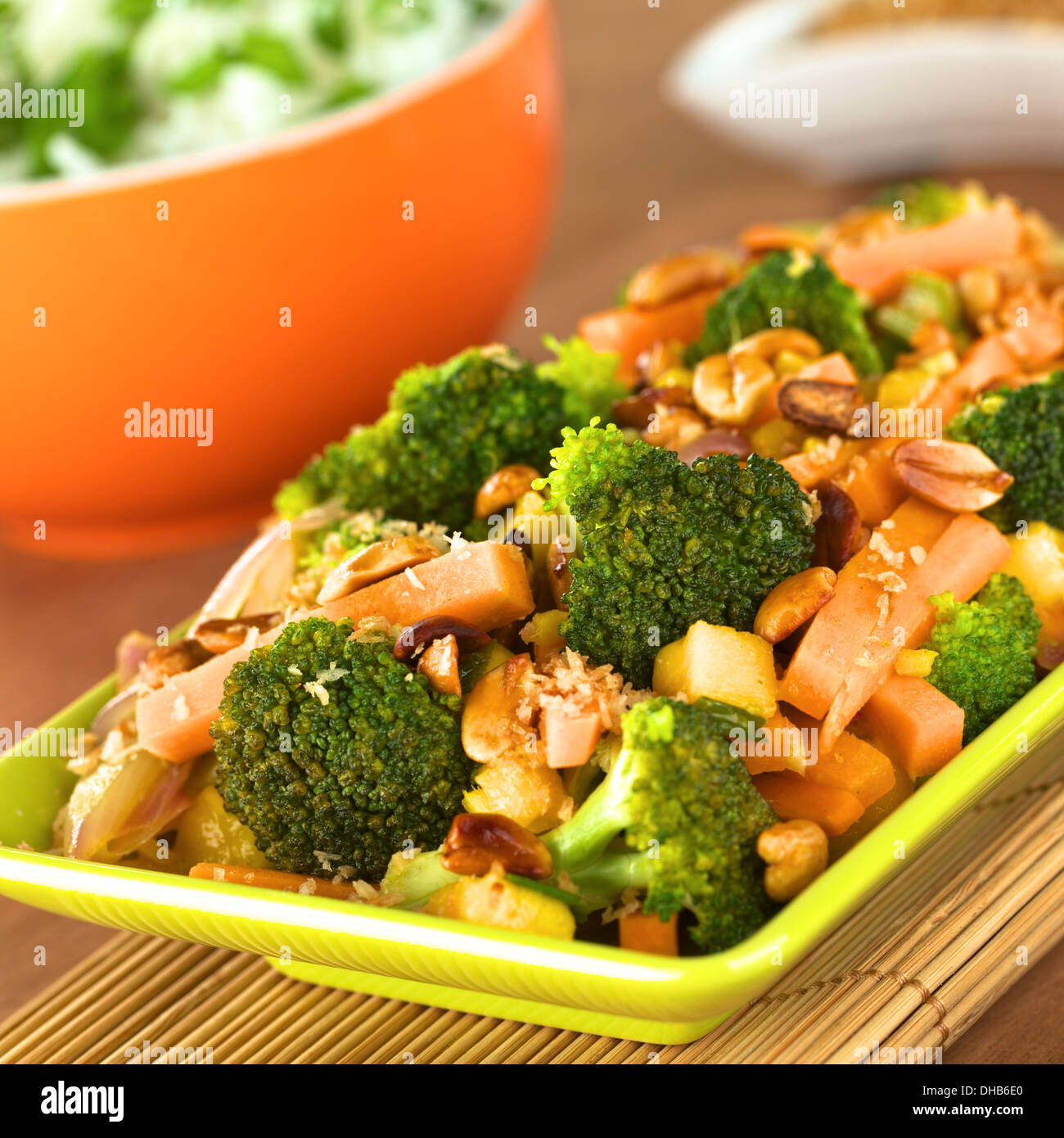 Vegetariano friggere in stile Thailandese con broccoli, carota, cipolla, mango con patatine fritte di scaglie di cocco e arachidi Foto Stock