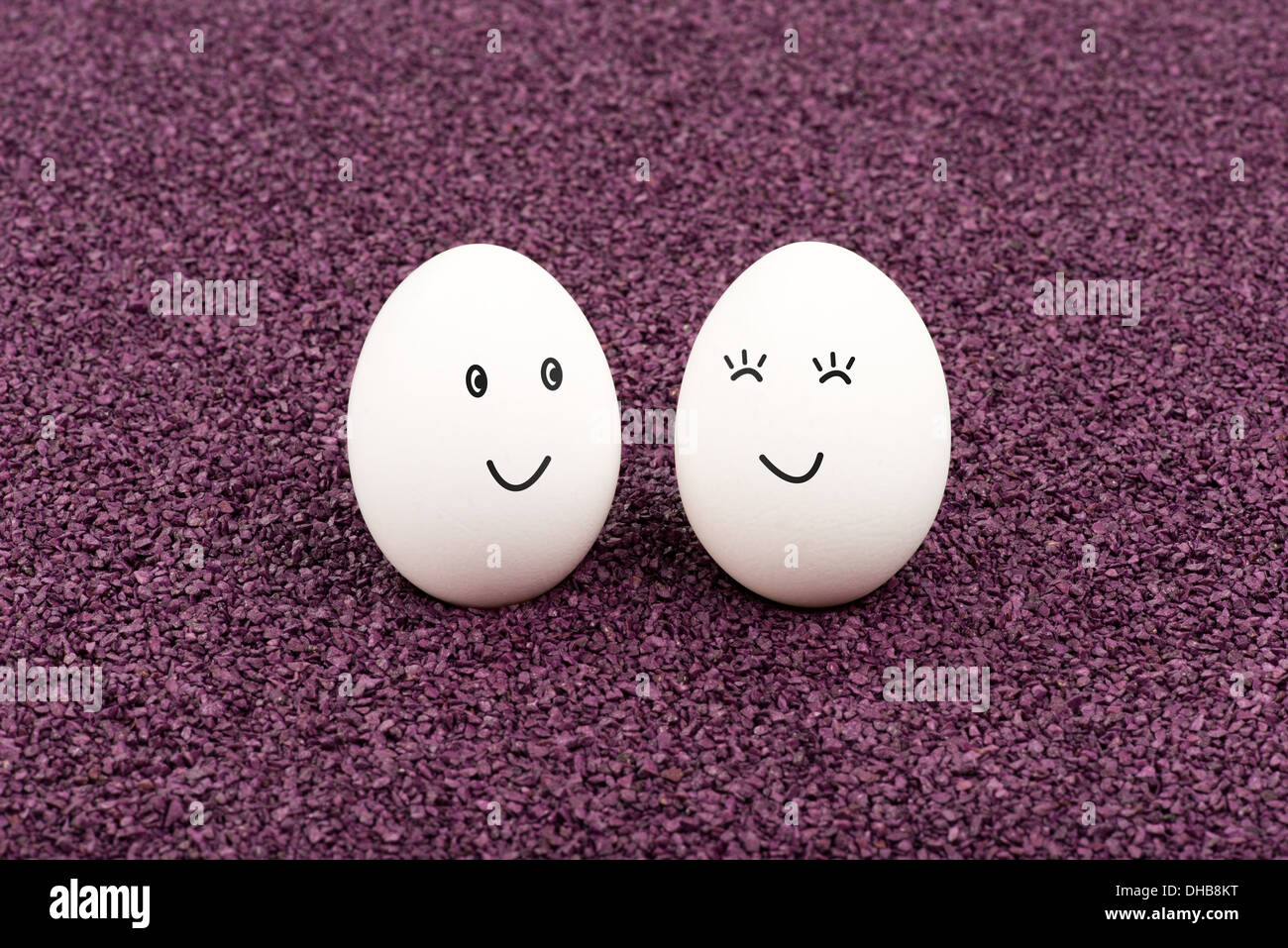 Due le uova bianche sulla sabbia viola il sorriso a ogni altro. Foto Stock