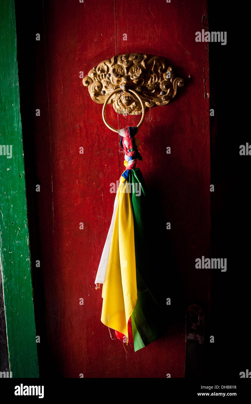 La vecchia porta al monastero buddista di Tempio decorata con antichi masaneta e fiocco. India, Ladakh, Thiksey Gompa Foto Stock
