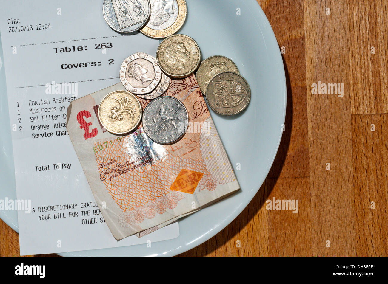 A sinistra di denaro come pagamento con fattura su un piattino in un ristorante o bar. Foto Stock