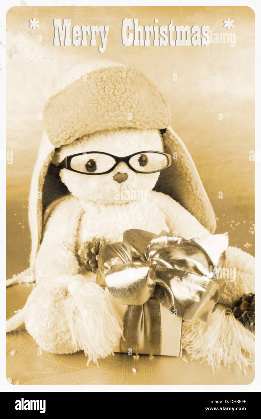 Retro cartolina - giocattolo morbido con gli occhiali, cappello e dono, verticale Foto Stock