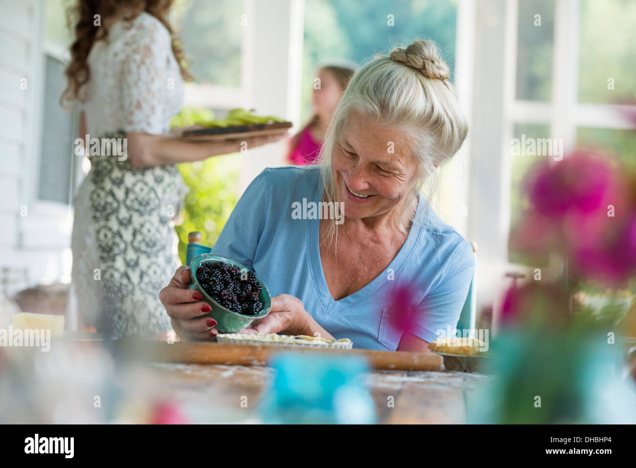 Una festa di famiglia in una casa colonica nel paese nello Stato di New York. Una donna matura vaschetta di contenimento delle carni di more. Foto Stock
