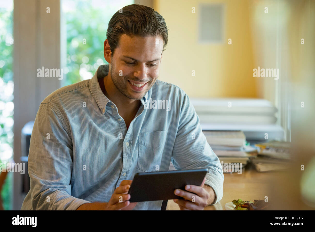 Una persona seduta da sola in un bar. Un uomo con una tavoletta digitale. Foto Stock