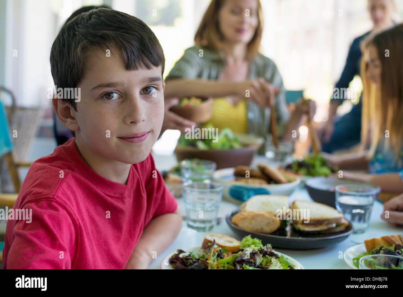 Una festa di famiglia intorno a un tavolo in una caffetteria. Adulti e bambini. Foto Stock